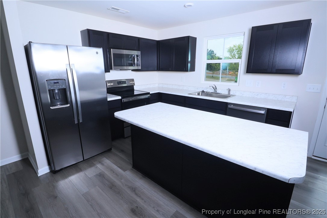 96 Cutty Way Lillington, NC 27546 - Photo 11 of 37 a kitchen with stainless steel appliances a refrigerator sink and microwave