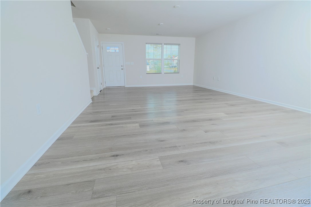 96 Cutty Way Lillington, NC 27546 - Photo 10 of 37 a view of an empty room with wooden floor and a window