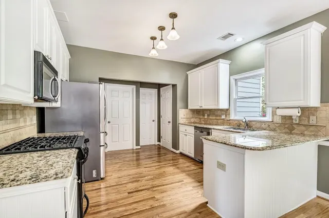 a kitchen with stainless steel appliances granite countertop a stove sink and cabinets
