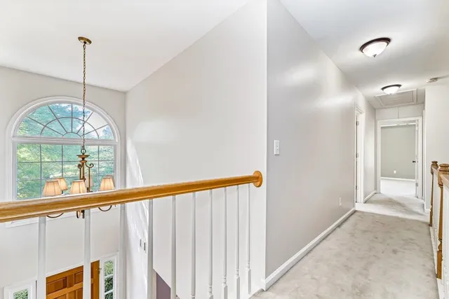 a view of a hallway to windows and chandelier