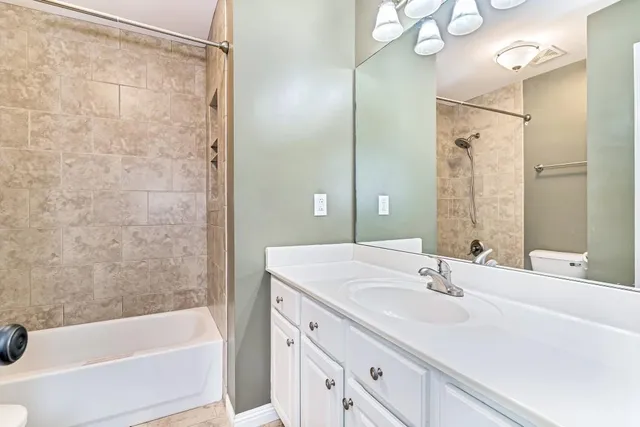 a bathroom with a bathtub shower sink vanity and a mirror