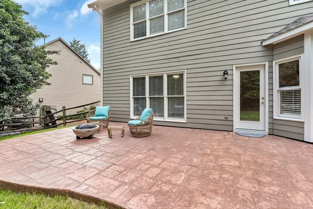 a backyard of a house with garden and outdoor seating