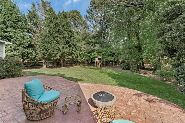 a view of a white house with a big yard and large trees