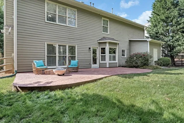 a view of a house with backyard and sitting area