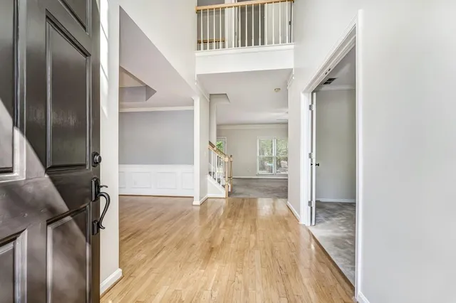 a view of a hallway with wooden floor and staircase