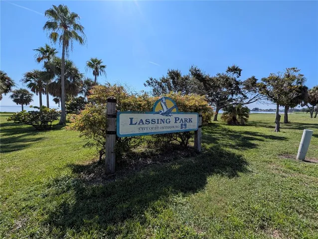 a sign board with a house in the background