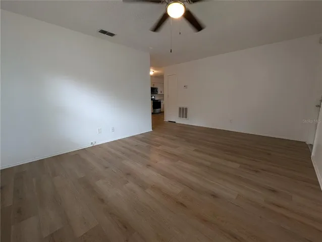 a view of an empty room with a chandelier fan