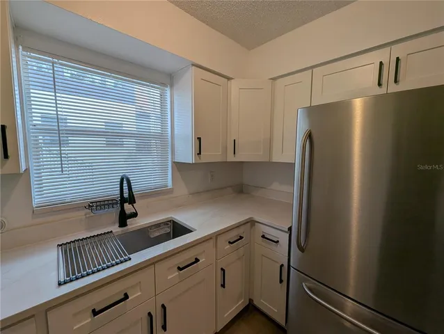 a kitchen with stainless steel appliances a refrigerator and a sink