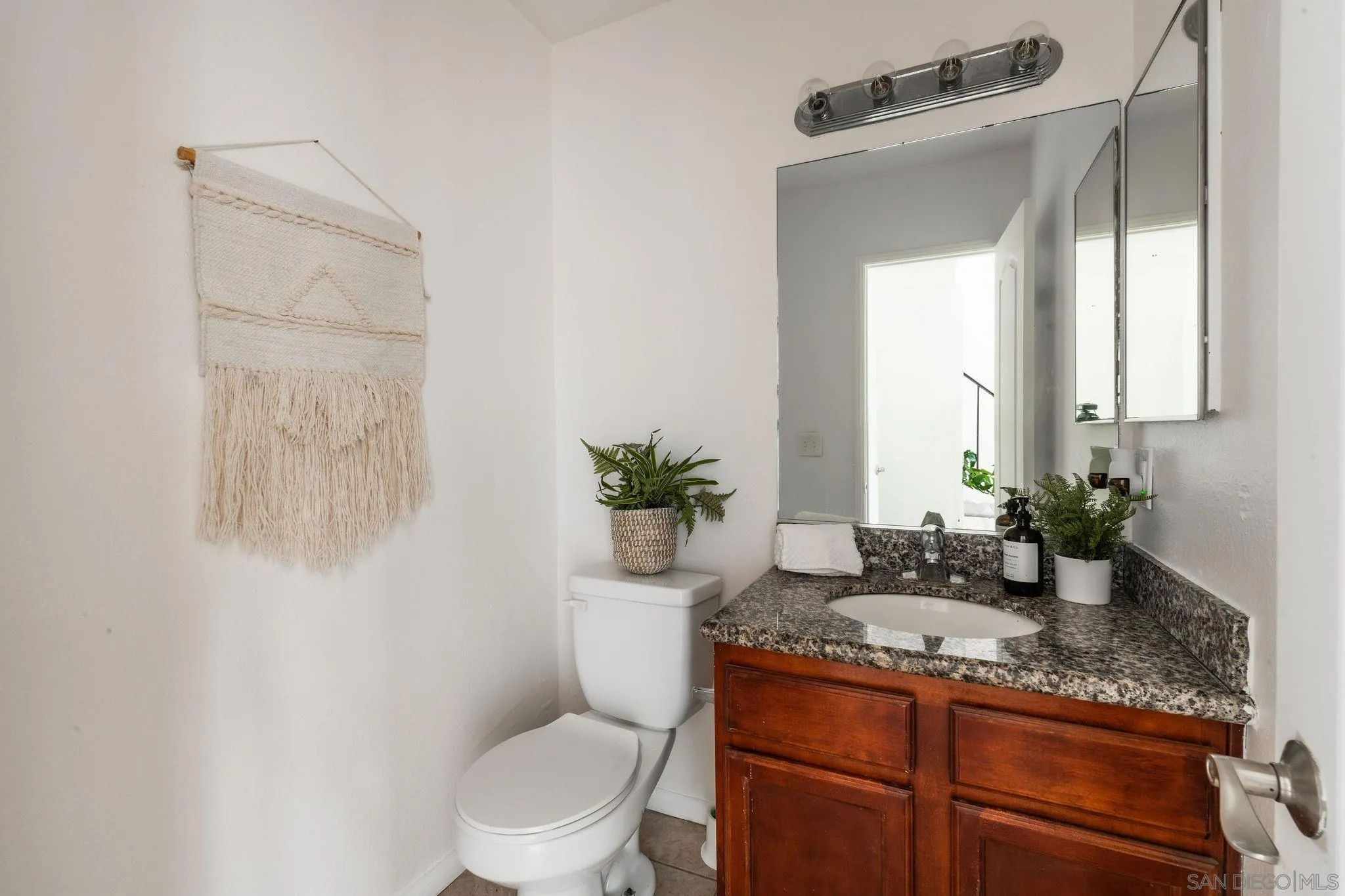 10235 Madrid Way, Unit 138 Spring Valley, CA 91977 - Photo 13 of 21 a bathroom with a granite countertop sink a toilet and a mirror