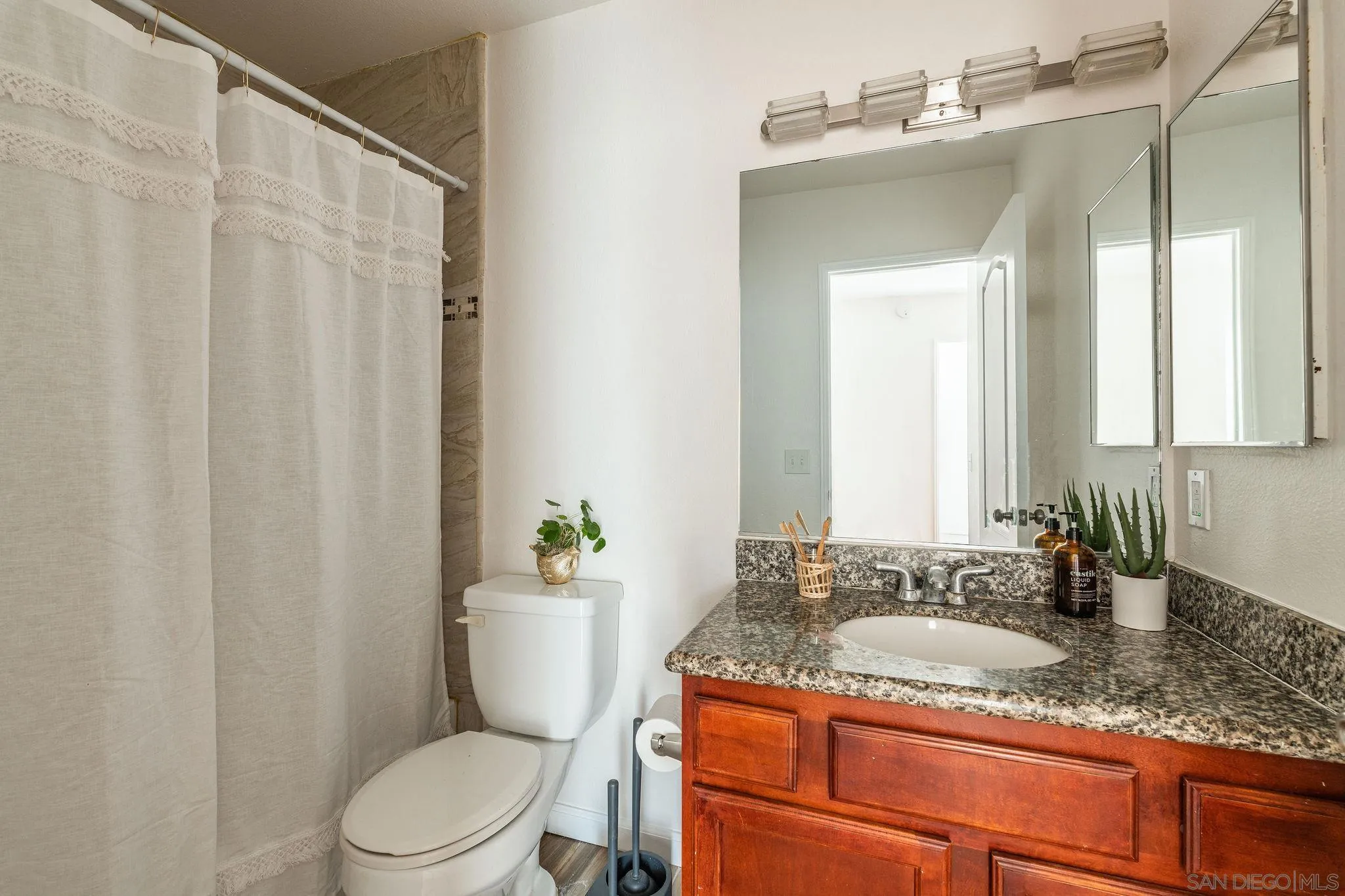 10235 Madrid Way, Unit 138 Spring Valley, CA 91977 - Photo 16 of 21 a bathroom with a granite countertop sink toilet and mirror
