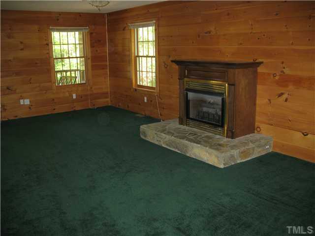 86 Log Home Road Timberlake, NC 27583 - Photo 3 of 12 an empty room with windows and fireplace