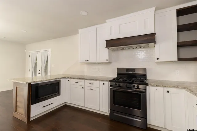 a kitchen with white cabinets and appliances