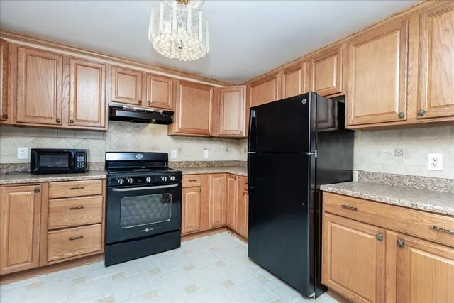 a kitchen with cabinets appliances a sink and a counter top space
