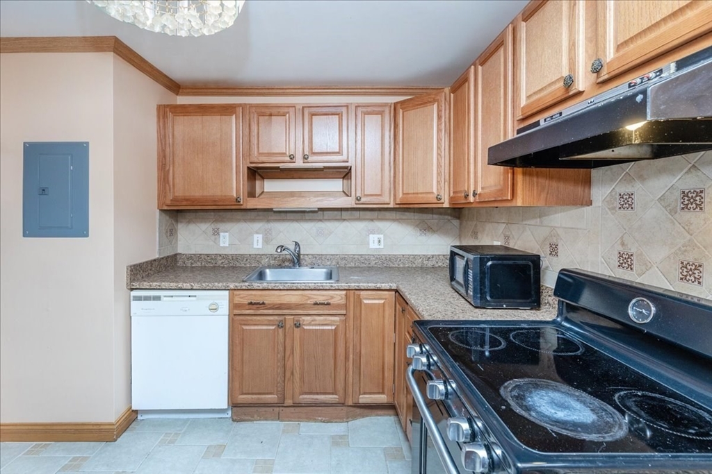 176 Maple Avenue, Unit 138 Rutland, MA 01543 - Photo 13 of 29 a kitchen with a stove a sink and a microwave