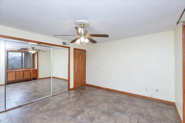 a view of a big room with chandelier fan and windows