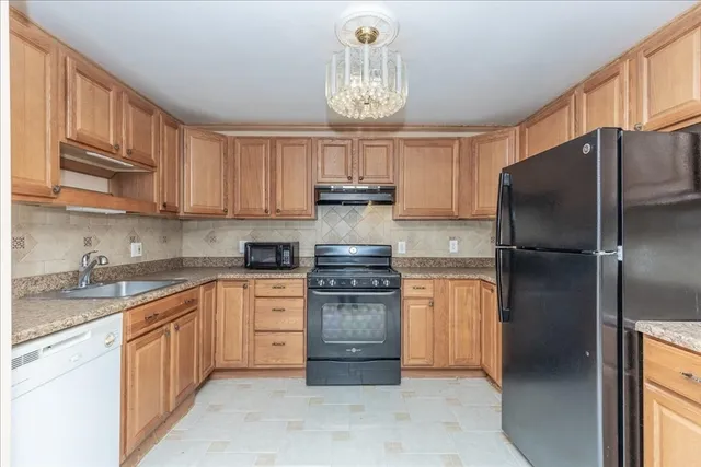 a kitchen with stainless steel appliances granite countertop a refrigerator stove top oven a sink and dishwasher