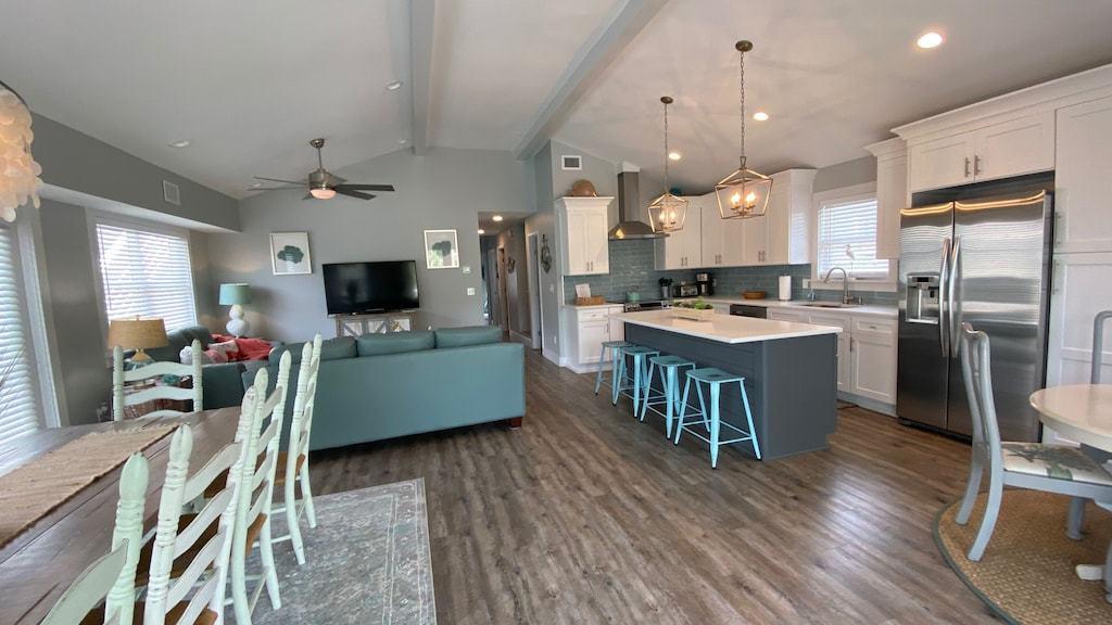 244 Magnolia Street Santa Rosa Beach, FL 32459 - Photo 6 of 32 a kitchen with stainless steel appliances kitchen island granite countertop a stove a refrigerator a oven a sink a dining table and chairs with wooden floor