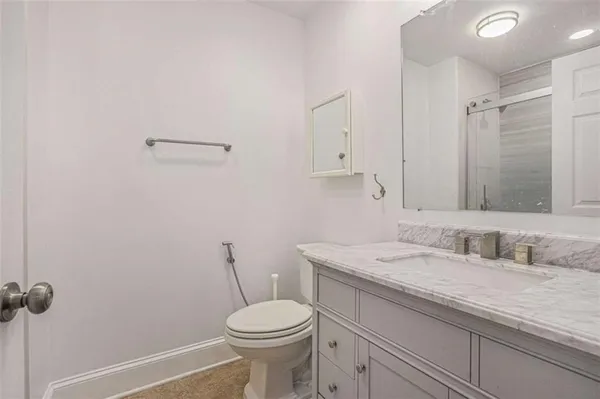 a bathroom with a granite countertop sink a toilet and a mirror