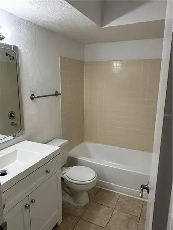 a bathroom with a toilet a sink a mirror and vanity