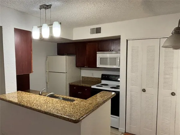 a kitchen with a refrigerator a stove a sink and a microwave