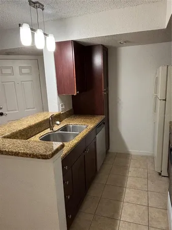 a kitchen with a sink refrigerator and cabinets