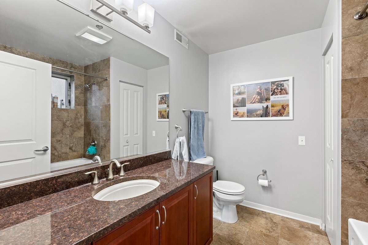 1159 North Hudson Avenue, Unit 6 Chicago, IL 60610 - Photo 16 of 24 a bathroom with a granite countertop toilet a sink and a mirror