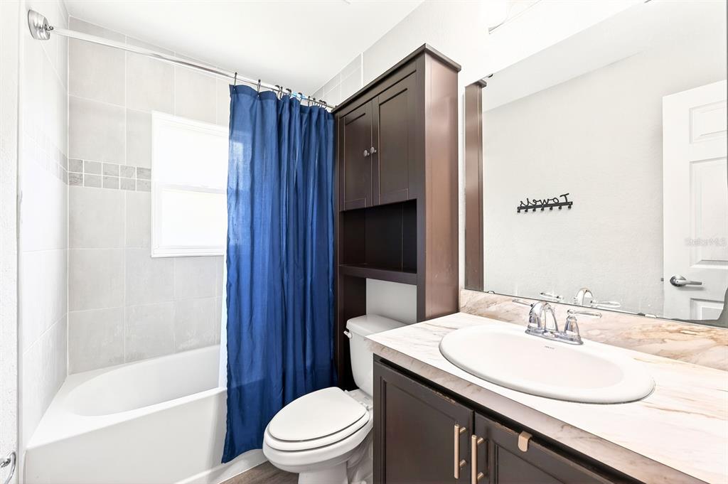 6348 Gardner Road Lakeland, FL 33813 - Photo 20 of 26 a bathroom with a granite countertop sink toilet and shower