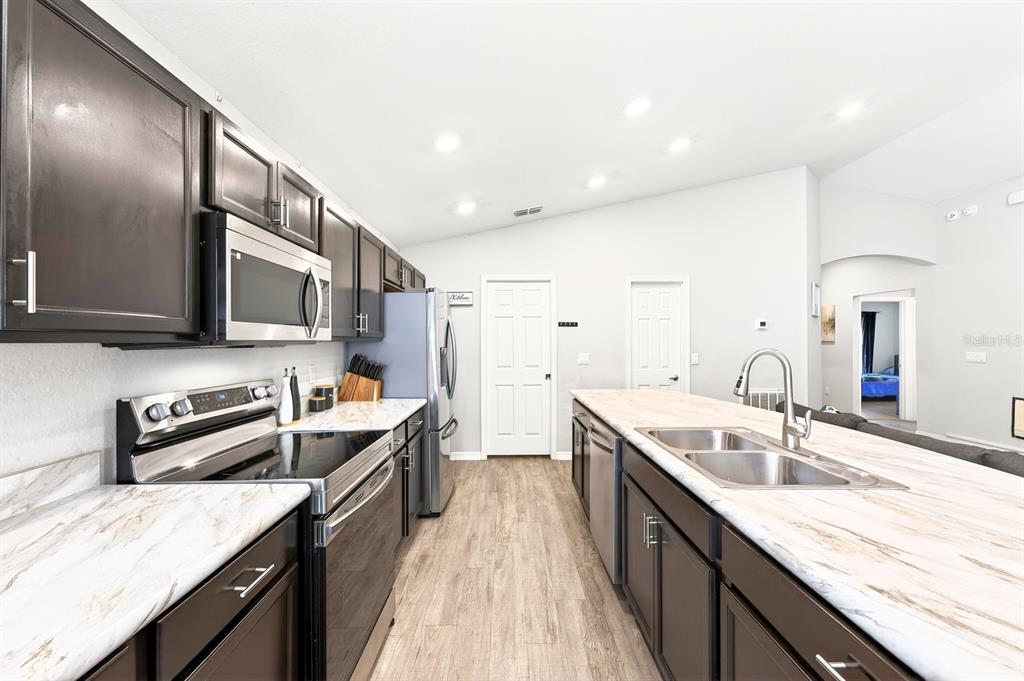 6348 Gardner Road Lakeland, FL 33813 - Photo 8 of 26 a kitchen with stainless steel appliances granite countertop a sink stove and cabinets