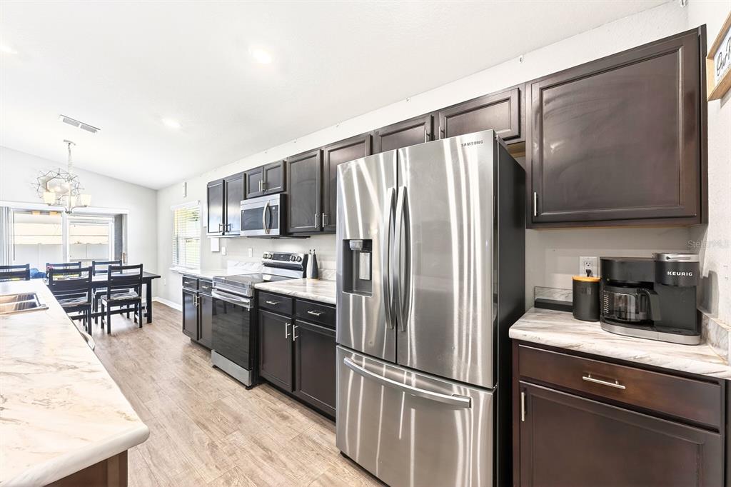 6348 Gardner Road Lakeland, FL 33813 - Photo 9 of 26 a kitchen with stainless steel appliances granite countertop a refrigerator stove microwave and sink