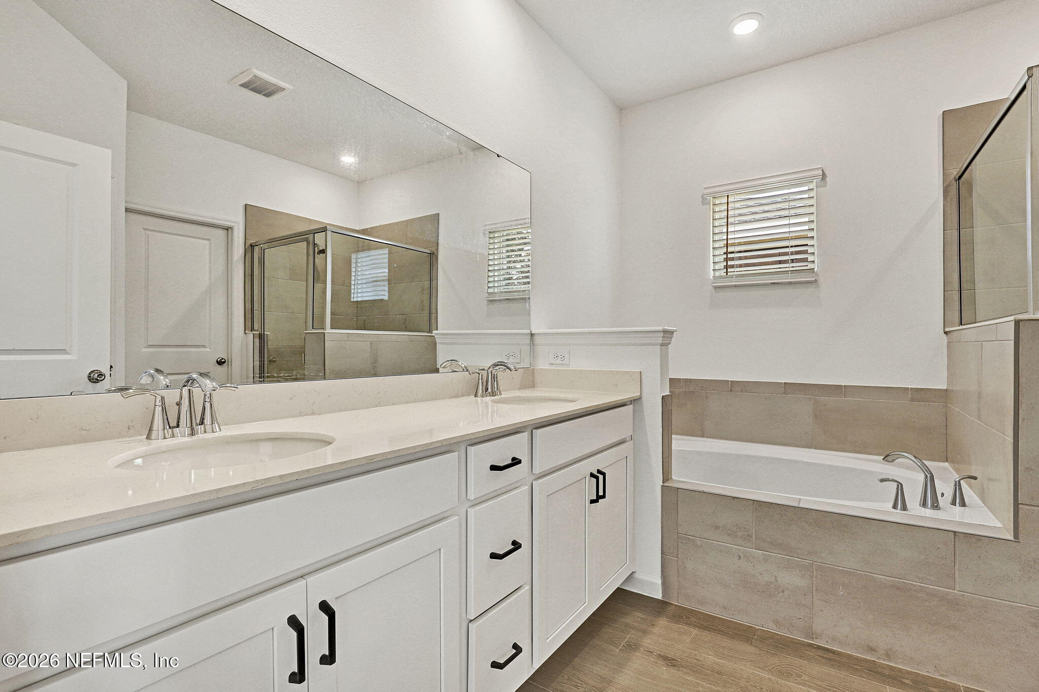89 Kingsley Pk Way St. Augustine, FL 32084 - Photo 19 of 29 a bathroom with double vanity sink a mirror and a bathtub