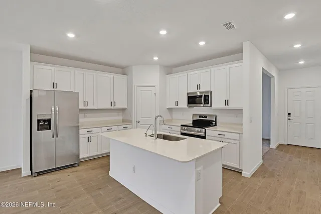 a kitchen with stainless steel appliances a refrigerator stove microwave and sink