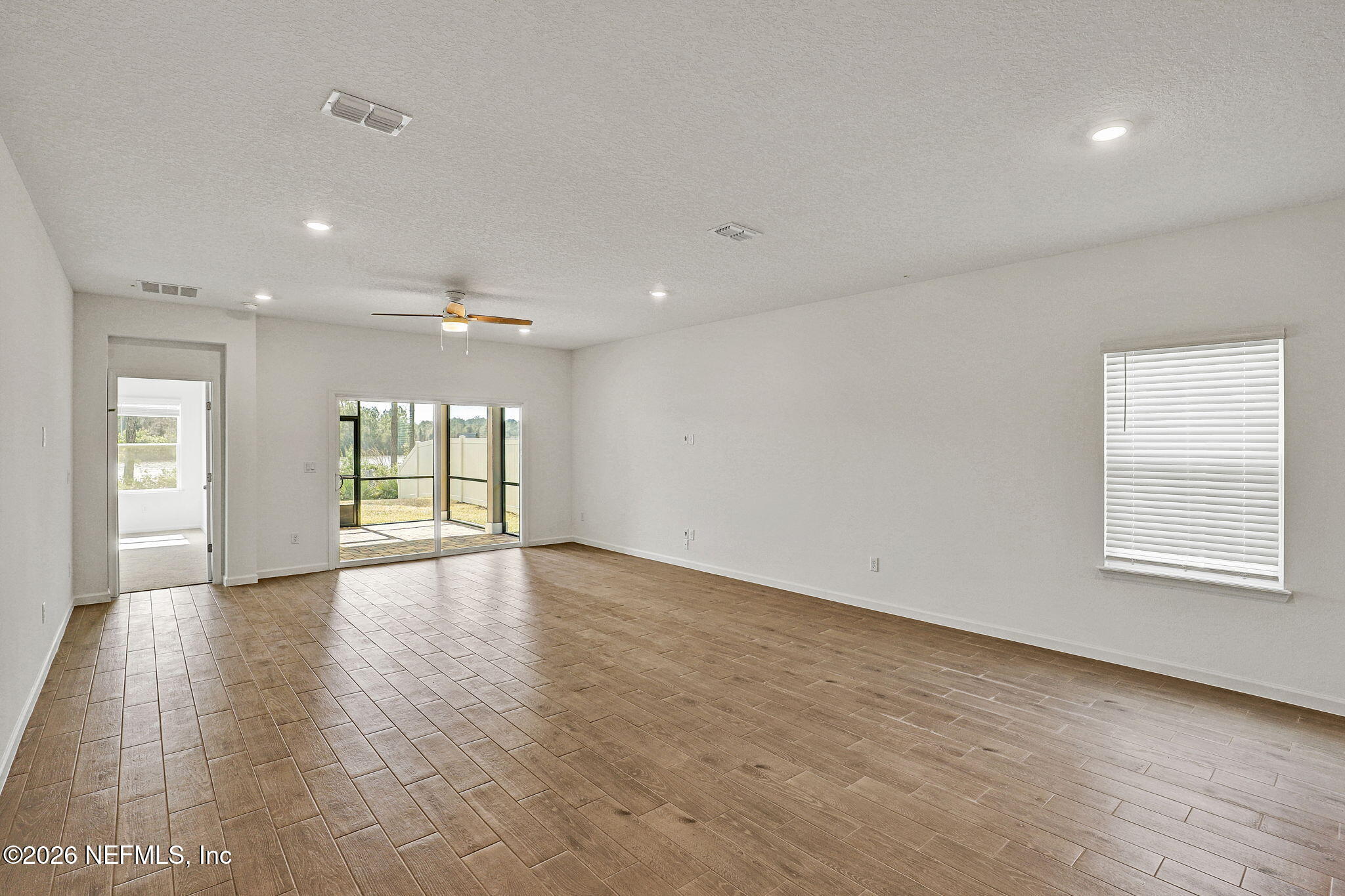 89 Kingsley Pk Way St. Augustine, FL 32084 - Photo 9 of 29 an empty room with wooden floor and windows