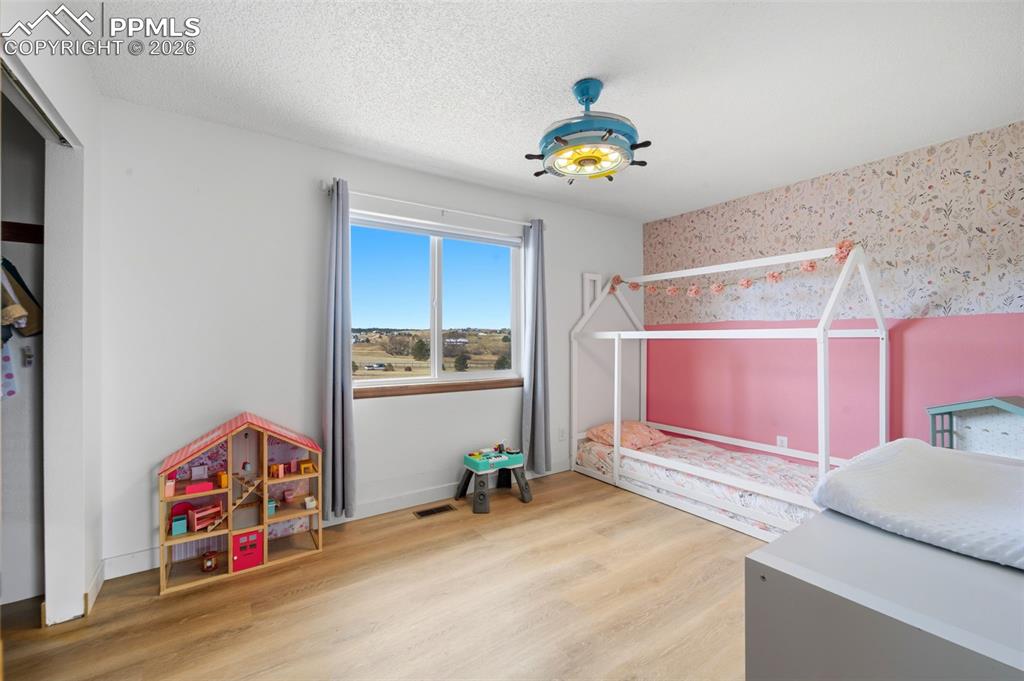 13815 Woodlake Road Elbert, CO 80106 - Photo 15 of 37 a bedroom with a bed and a chandelier