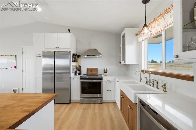 a modern kitchen with stainless steel appliances granite countertop a refrigerator and a sink