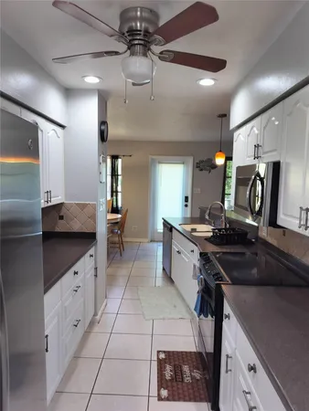 a large kitchen with stainless steel appliances granite countertop a sink and cabinets