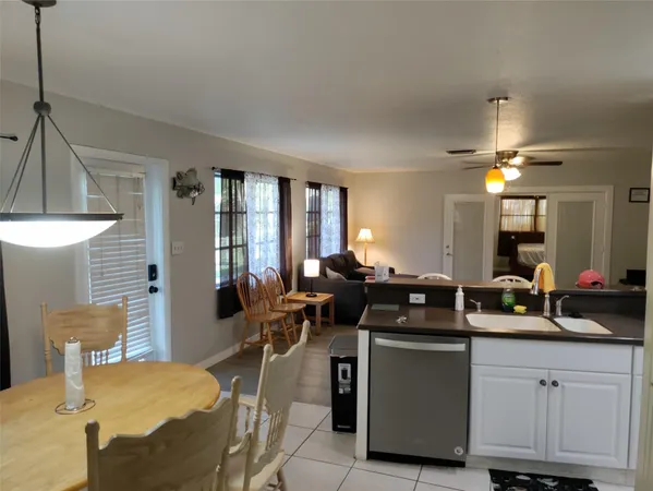 a kitchen with a sink chairs and cabinets