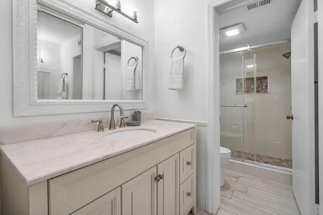 a bathroom with a sink a toilet and shower