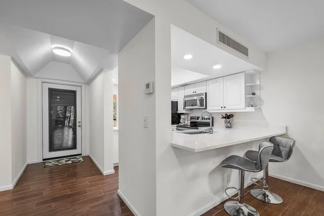 a kitchen with kitchen island wooden cabinets and refrigerator