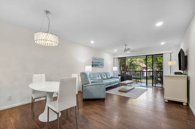 a living room with furniture floor to ceiling window and wooden floor