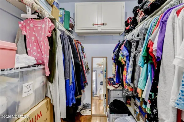 a view of walk in closet with clothes