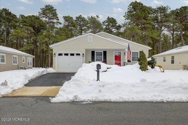 a front view of house with yard and trees in the background