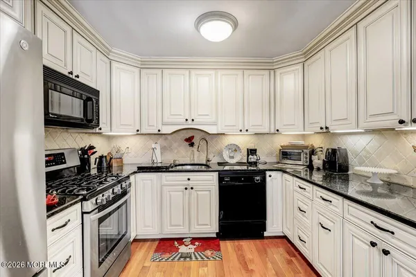 a kitchen with stainless steel appliances granite countertop a sink and cabinets