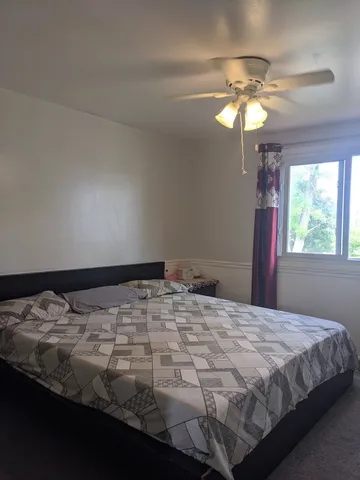 a bedroom with a bed dresser and window