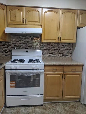 a kitchen with stainless steel appliances granite countertop a sink a stove and a microwave