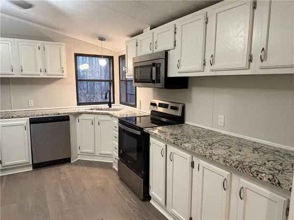 a kitchen with stainless steel appliances granite countertop a sink stove and microwave