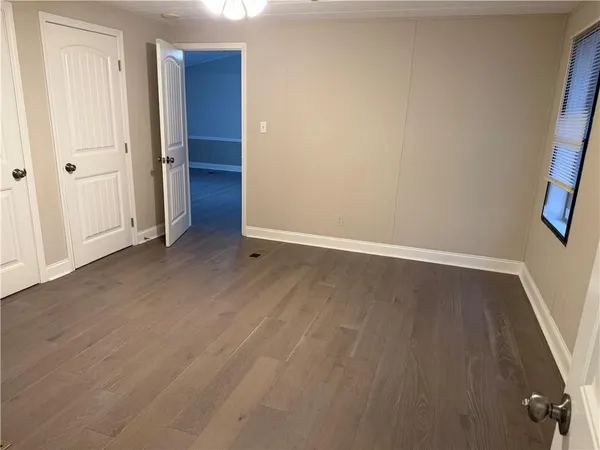 an empty room with wooden floor and closet