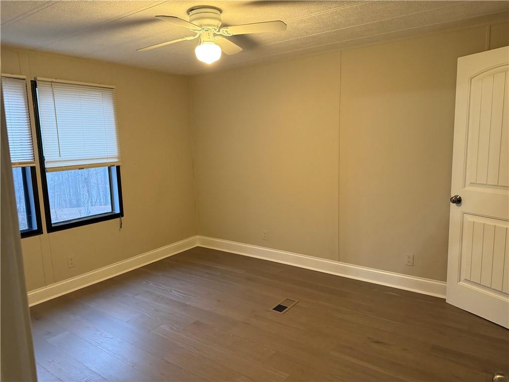 7 Poole Lane Talking Rock, GA 30175 - Photo 18 of 20 an empty room with wooden floor and fan