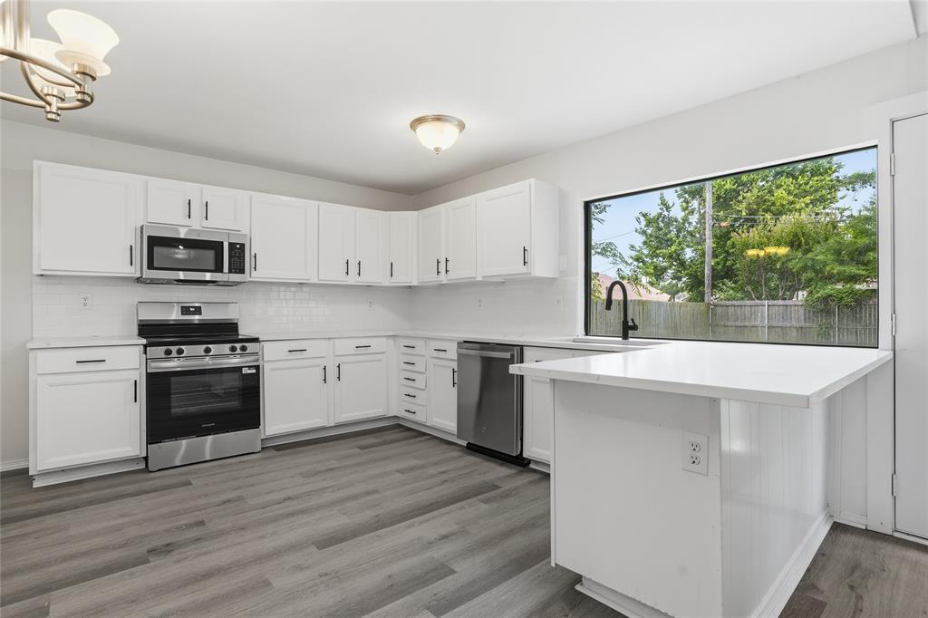 403 Redbud Drive Forney, TX 75126 - Photo 7 of 17 a kitchen with a stove a sink and a microwave