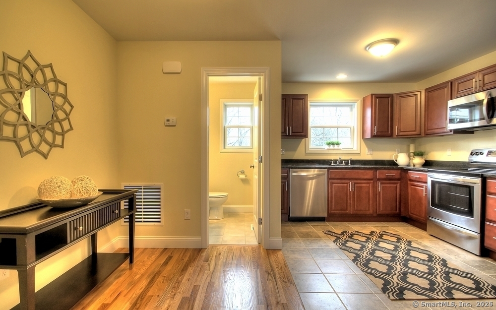 a kitchen with stainless steel appliances granite countertop a stove a sink and a microwave