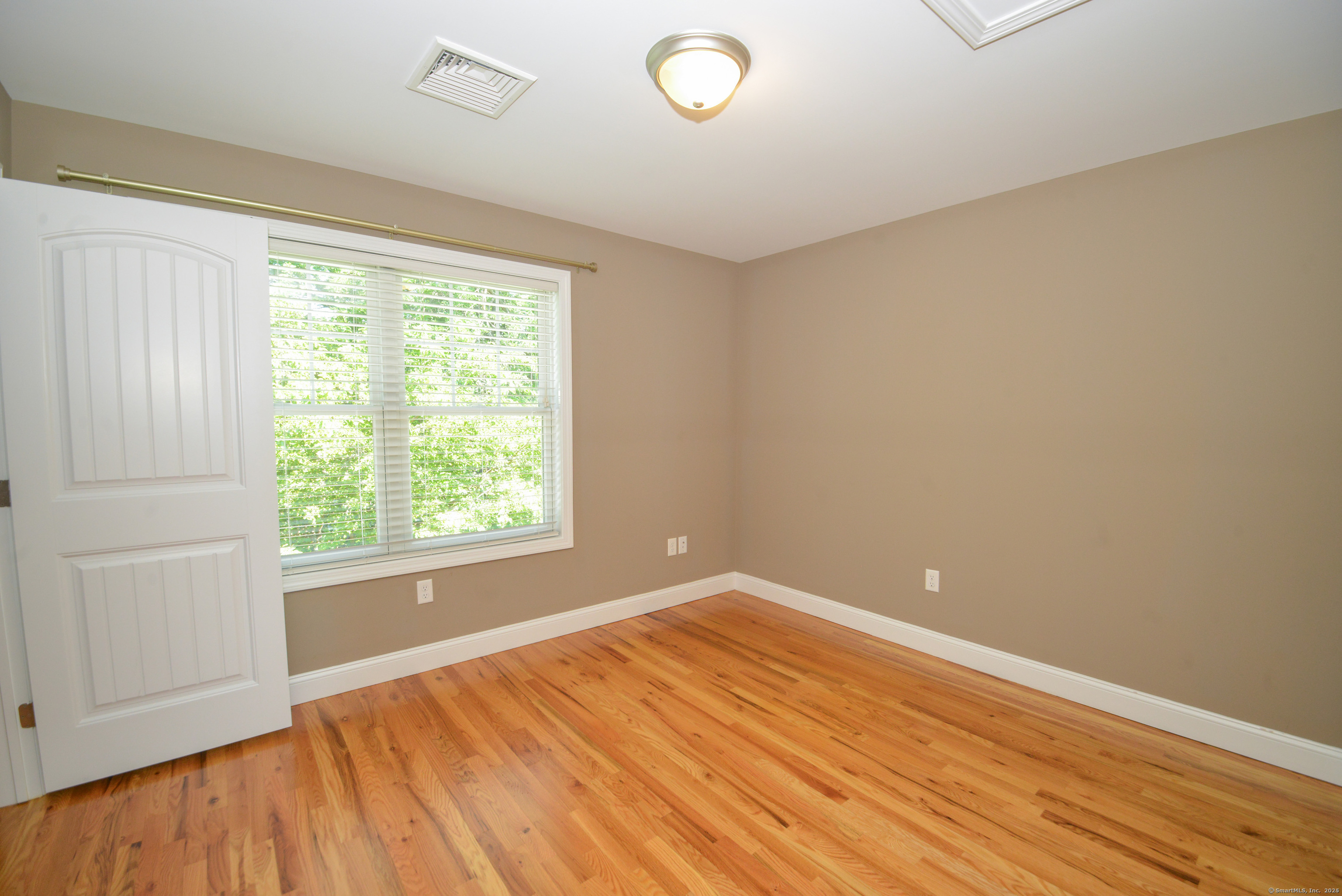231 West Main Street, Unit C Milford, CT 06460 - Photo 11 of 18 an empty room with wooden floor and windows